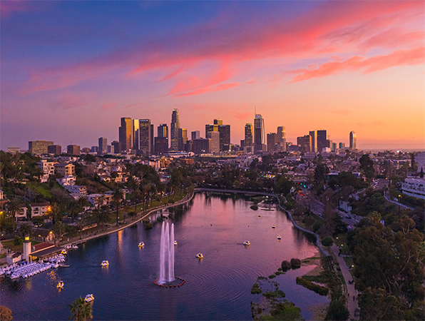 Vue aérienne des gratte-ciel de Los Angeles, avec un parc et un lac au premier plan.