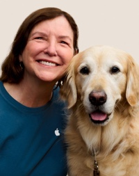 Portrait d’un membre de l’équipe Apple Retail souriant avec un chien guide.