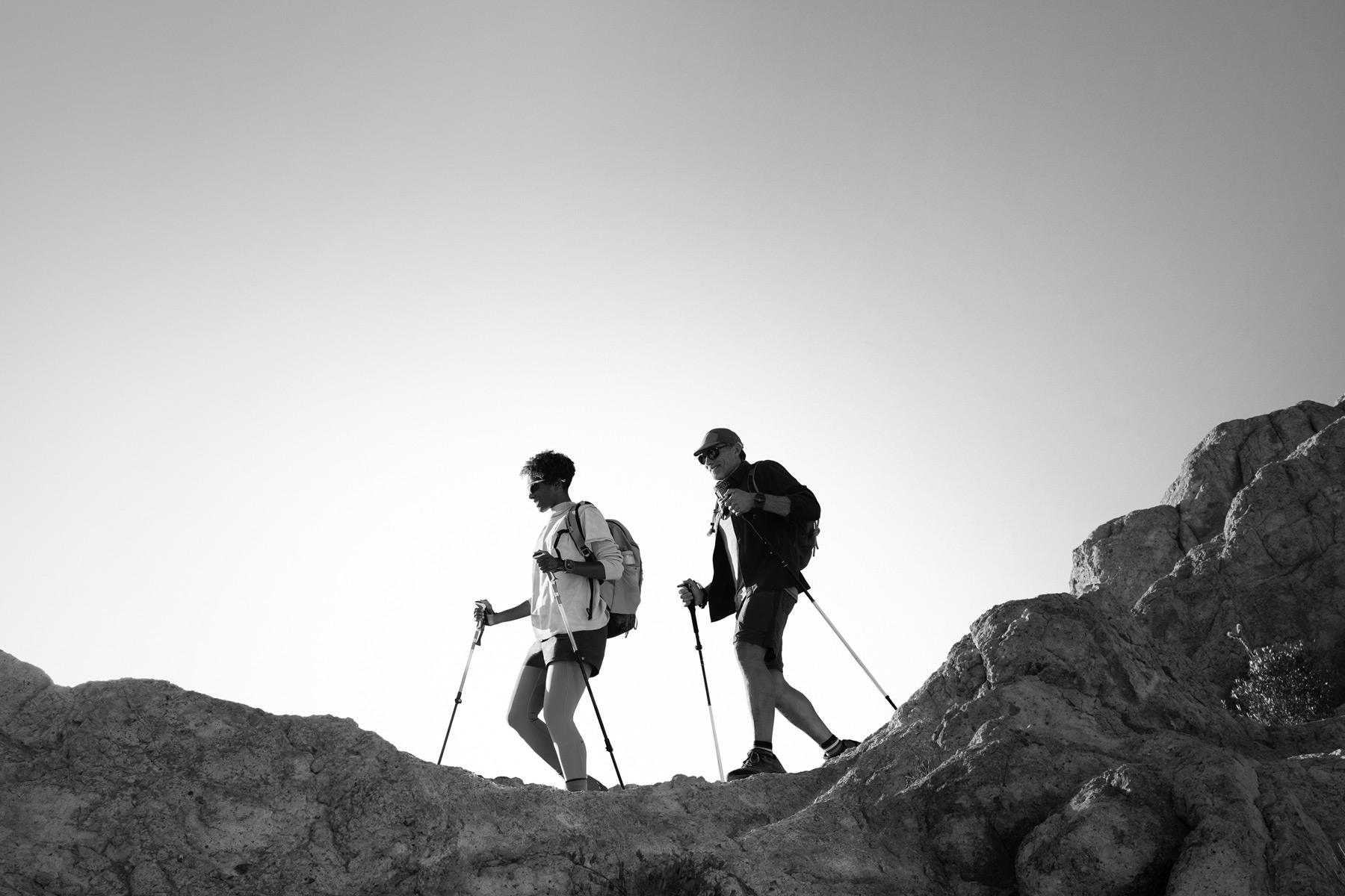 Dos personas con un Apple Watch Ultra 3 hacen senderismo en la montaña.