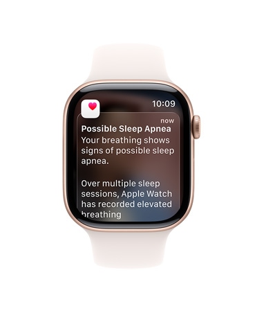 Apple Watch Series 11, rozéaranyszínű alumíniumtok, megnyitott alvási apnoéról szóló értesítés, jobb oldali nézet, Digital Crown, lágy rózsaszín sportszíj