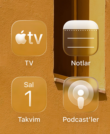 Apple TV uygulaması, Notlar, Takvim ve Podcast’ler olmak üzere dört yarı saydam uygulama simgesinden oluşan ızgara arka planı yansıtıyor