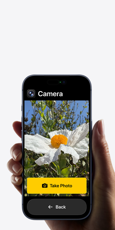 iPhone 17 Pro 螢幕顯示簡化的相機 app 介面,取景框中有一朵白色的花,介面包含「Take Photo」按鈕,底下還有個「Back」按鈕