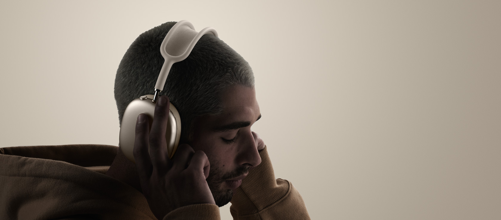 شخص يضع على رأسه سماعات الرأس AirPods&nbsp;Max&nbsp;2، الجهة الخارجية الجانبية، يلمس بطانة الأذنين