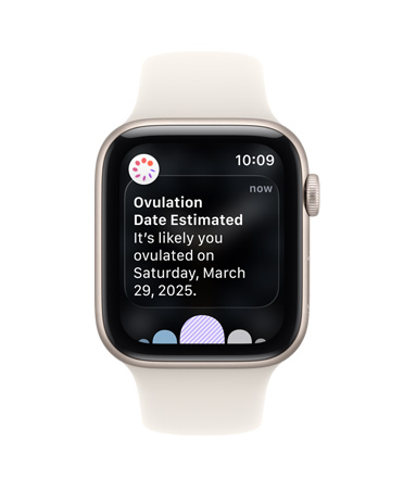 Apple Watch SE 3, aluminiumboett i färgen stjärnglans, notis med beräknat ägglossningsdatum från Cykelkoll i appen Hälsa, Digital Crown, sportband i färgen stjärnglans