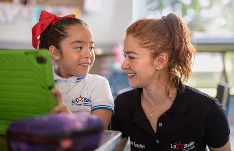 Eleane Ruth Guzmán Padilla tillsammans med en elev i ett klassrum på Colegio Cristóbal Colón.