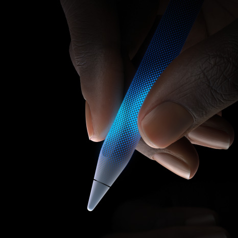 Bir kullanıcı Apple Pencil Pro’yu tutuyor, Apple Pencil’ın ucunun hemen üstündeki dokunmaya duyarlı kısmı dokunsal geri bildirimi gösteriyor