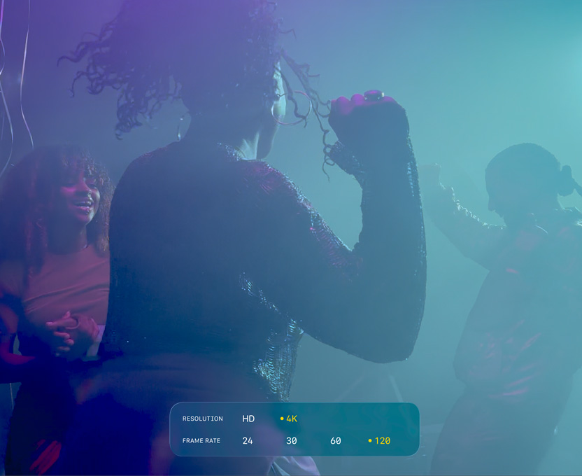 En skärm där personer dansar i en mörk miljö, filmen visar möjligheterna med Dolby Vision 4K med 120 bilder/s