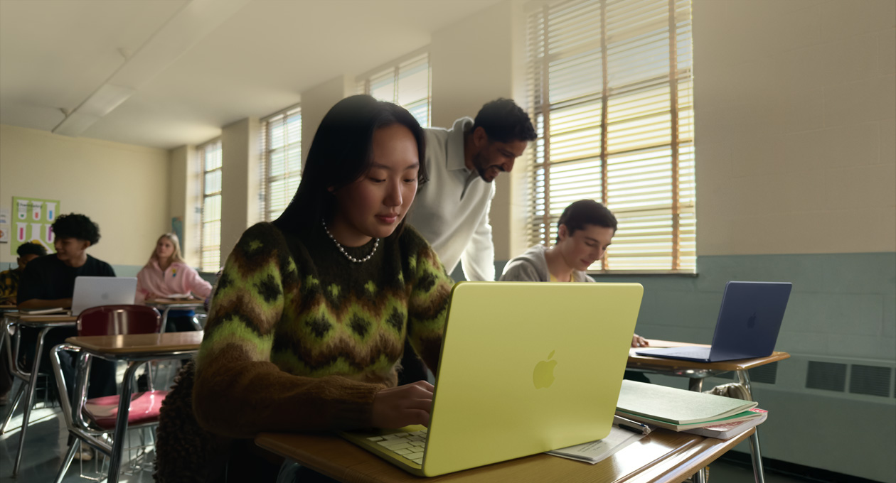 En elev använder MacBook Neo i färgen citrus, utan anslutna kablar, i ett klassrum