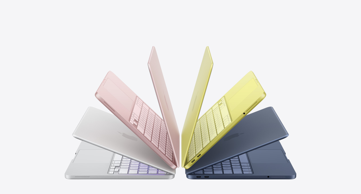 MacBook Neo-datorer i färgerna silver, rosé, citrus och indigo, något öppna och ordnade i bågformation