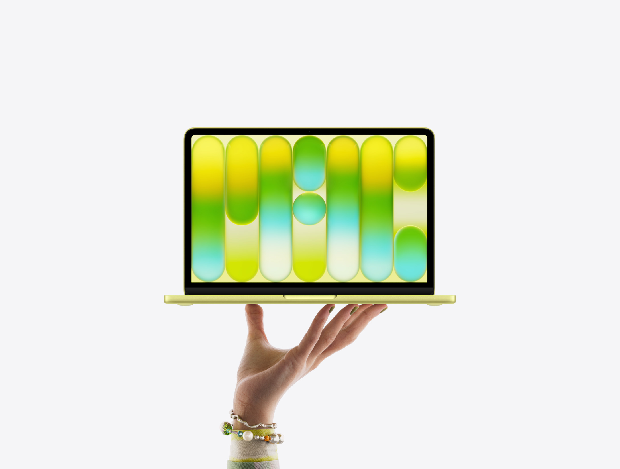 MacBook Neo i färgen citrus som balanserar på en öppen hands fingertoppar, med ett färgglatt abstrakt mönster på skärmen