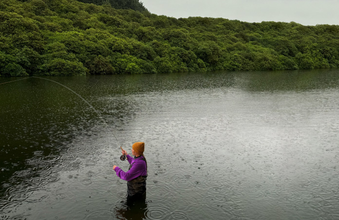 Photo d’une femme pêchant à la mouche dans une rivière, outil Pixelmator Pro supprimant des objets indésirables