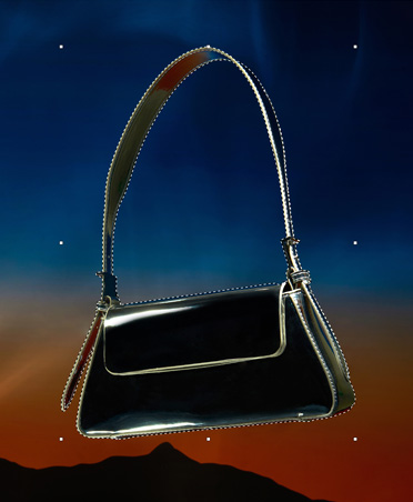 Un sac à main noir dont le contour est tracé par des lignes pointillées, outil de sélection, retouche d’image, coucher de soleil avec silhouette de montagnes en arrière-plan